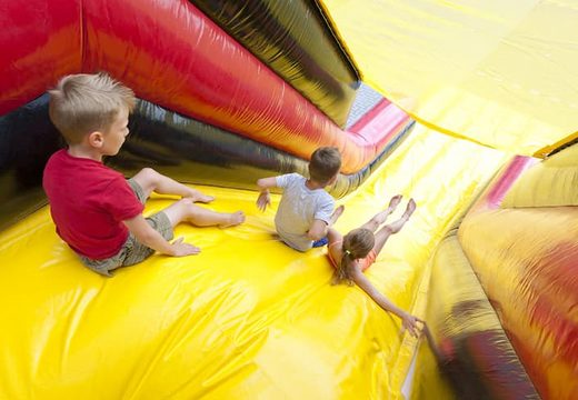 Professionele Toren opblaasbaar te koop in geel en rood voor zeskamp spel klimmen voor kinderen bij JB Inflatables