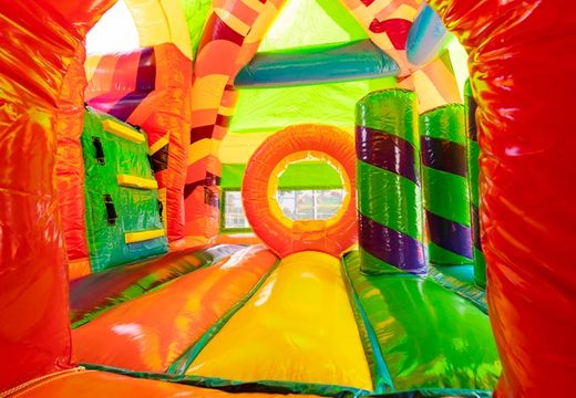 Castelo inflável coberto com slide no tema hippie com muitas cores